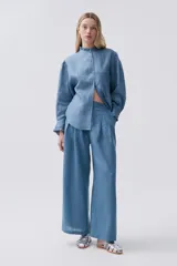 Camisa blanca de lino con cuello mao con volados, mangas largas y calce relajado.