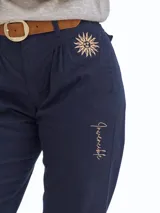 Bombacha de campo de gabardina en color azul marino, con diseño de pinzas en la cintura. Presenta un bordado de un sol en la parte superior y la palabra 'Invencible' bordada en el lateral de la pierna. Incluye puños ajustables con botones en el ruedo.