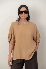 Blusa de lino color tostado, de corte holgado y manga corta con inserción de puntilla bordada.