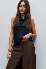 Pantalón wide leg de tiro alto, confeccionado en tela ligera de caída fluida y brillo sutil.
