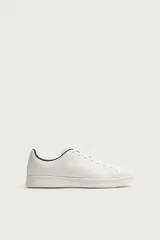 Zapatilla de cordones con parte superior fabricada en piel, de horma redonda y suela a tono.