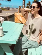 Sweater de punto color beige con mangas ranglan color marrón y aplique de cuero con forma de cactus en el frente.