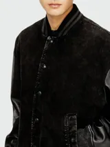 Campera estilo bomber Diesel modelo L-Nyn, color negro, con cuerpo de cuero texturizado y mangas de cuero liso, cierre frontal con broches a presión y cuello, puños y dobladillo de punto elástico rayado.
