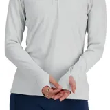 Remera deportiva New Balance negra de manga larga con cuello alto y cierre de cremallera corto. Cuenta con orificios para los pulgares en los puños y logo reflectante en el pecho.