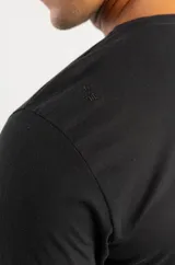 Camiseta negra de corte regular con cuello redondo y mangas cortas. Presenta un estampado gráfico pequeño en el lado izquierdo del pecho con la frase 'There is no substitute for Airton'.