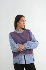 Chaleco de punto en color violeta, con cuello redondo y bordes deshilachados. Presenta una textura suave y un corte recto.