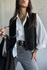 Chaleco negro de gamuza con diseño calado de flores en el ruedo y corte recto.