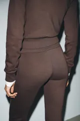 Pantalón de tiro alto color marrón, con cintura elástica y bajo acampanado (flare).