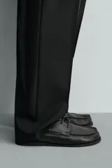 Zapato náutico de piel color negro con acabado abatanado, cordones de cuero y suela a tono.