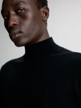 Sweater negro de cuello perkins confeccionado en lana merino extrafina. Tiene cuello, puños y bajo de canalé.