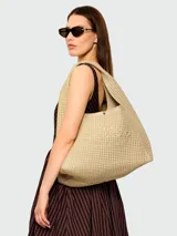 Cartera Marc Jacobs modelo The Lurex Crochet Sack Bag, color beige y dorado, tipo tote bag tejida en crochet de lurex con el texto 'THE SACK BAG MARC JACOBS' bordado en el frente.