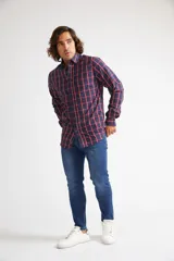 Camisa de manga larga con cuello clásico y cierre frontal abotonado. Presenta un estampado de cuadros en tonos azul marino y rojo. Confeccionada en algodón, cuenta con un corte slim fit y logo bordado en el pecho.