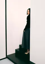 Cardigan de punto acanalado color negro, con cuello en V y detalle de pelo sintético en el cuello. Presenta cierre frontal con botones, diseño entallado y manga larga.