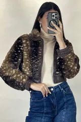 Campera corta de piel sintética con estampado animal print tipo ciervo, cuello clásico, cierre frontal y puños elásticos en cuero sintético.