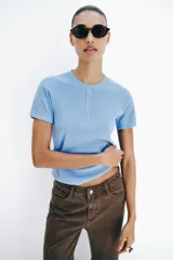 Jeans de tiro medio y corte recto, color marrón chocolate. Presenta un diseño de cinco bolsillos y detalles laterales con tejido de crochet a tono a lo largo de las piernas.