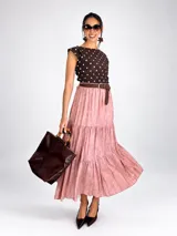 Blusa sin mangas de viscosa color negro con estampado de lunares blancos, cuello redondo y cintura fruncida con elástico.