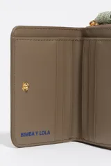 Billetera compacta de nylon color beige, con cierre de cremallera perimetral y tirador decorativo con cordón. Presenta el logo metálico de la marca en el frente.