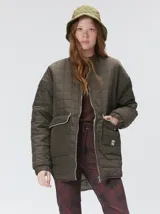 Campera reversible capitoneada con cierre frontal. Un lado es de color negro y el otro es de color beige, ambos con diseño acolchado. Cuenta con cuello redondo, mangas largas y bolsillos laterales.