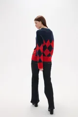 Sweater de tejido jacquard con diseño de rombos en colores azul marino y rojo, de corte holgado, manga larga y cuello redondo.