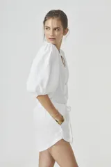 Camisa blanca de lino con cuello mao, mangas globo al codo y botones de nácar.