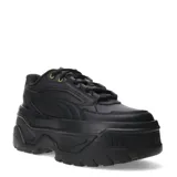 Championes Puma modelo Karmen, de diseño urbano con plataforma elevada. Presentan un exterior sintético en color negro, con cordones al tono y detalles metálicos en los ojales superiores. Su suela robusta de goma proporciona estabilidad y un estilo moderno.