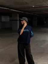 Remera de algodón negra con cuello alto y corte boxy/oversize. Estampa frontal y en mangas con diseño tribal en color blanco.