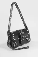 Cartera de hombro de cuero sintético marrón oscuro, con diseño de solapa frontal adornada con tachas metálicas plateadas, hebillas decorativas y correa ajustable.