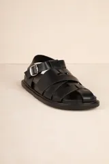 Sandalias bajas tipo gladiador, color negro, con tiras entrelazadas y hebilla metálica ajustable.