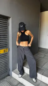 Pantalón de corte sastrero y tiro bajo, con diseño de pierna ancha y holgada. Presenta cierre frontal con botón y bolsillos laterales.