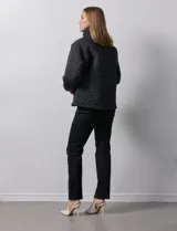 Campera beige capitoneada con capucha, cierre frontal y bolsillos laterales.