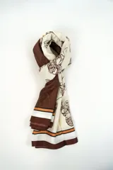 Pañuelo rectangular en tonos beige y marrón, con diseño estampado floral y franjas decorativas en los extremos.