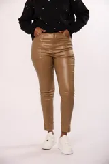 Pantalon chupin de ecocuero color tostado, con costura vertical decorativa en el frente y cierre frontal.