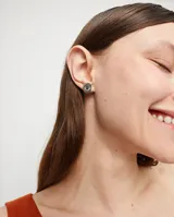Par de aros de botón plateados con cristal facetado verde.