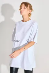 Remerón blanco de jersey 24/1 peinado, corte oversized, mangas cortas y ruedo ancho. Estampa serigrafiada en frente y espalda a contratono.