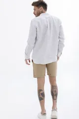 Camisa celeste a rayas verticales blancas, de manga larga y corte clásico.