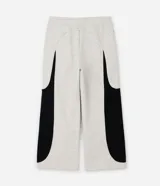 Pantalón de jogging confeccionado en algodón y poliéster, con diseño de paneles laterales en contraste de color negro. Presenta cintura elástica con cordón ajustable y bolsillos laterales.