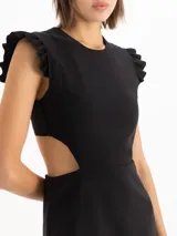 Vestido corto negro con escote redondo, volados en las sisas, aberturas laterales en la cintura y falda evasé con volado en el ruedo.
