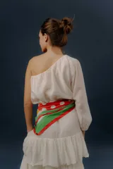 Blusa blanca de un solo hombro con manga larga abullonada y diseño holgado.