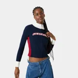 Cardigan de punto Eme Studios modelo Betty Navy, de color azul marino con cuello alto y puños blancos, y detalles en rojo en los laterales. Cuenta con cierre frontal de cremallera y logo bordado en relieve en el pecho.