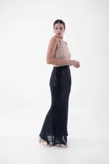 Vestido largo con cuello halter enteramente cubierto de lentejuelas, que combina un cuerpo superior en tono rosado y una falda larga en color negro.
