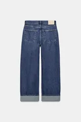 Jeans de tiro medio con corte baggy y pierna relajada. Presenta diseño de cinco bolsillos, cierre frontal con cremallera y botón, y bajo con vuelta marcada.