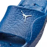 Ojotas tipo slide Jordan Franchise Shower, color azul vibrante, con tira ancha superior que presenta el logo Jumpman en blanco. La plantilla texturizada incluye el mismo logo en relieve para mayor agarre.