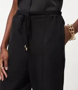 Pantalón de corte recto confeccionado en tejido airflow de poliéster. Presenta cintura elástica con cinturón del mismo tejido para lazo frontal y una caída fluida.