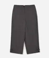 Pantalón de sastrería gris de corte wide leg, con cintura alta, bolsillos laterales y detalles de ajustes con botones en los ruedos.