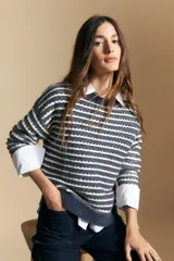 Sweater de punto con diseño de rayas horizontales en tonos tierra, con textura acanalada y cuello redondo. Presenta un corte relajado y mangas largas.