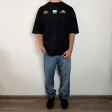 Remera de corte oversize color blanco con estampado gráfico en la espalda en color verde oliva que incluye el texto 'SOFT DISORDER' y detalles de marca.