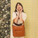 Cartera mochila negra de símil cuero con diseño convertible, bolsillo frontal con cierre y tirador, apertura superior doble y correas ajustables.