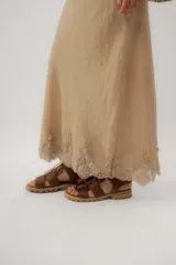 Pollera larga de lino color marrón con detalle de encaje en el ruedo.