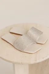 Sandalias bajas color blanco con tira ancha cubierta de strass.