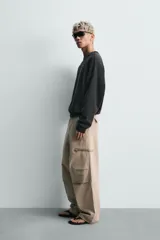 Sudadera de corte relaxed fit confeccionada en tejido de algodón con interior de rizo. Presenta cuello redondo, manga larga y acabados en rib, con un acabado de efecto lavado que le otorga una apariencia única.